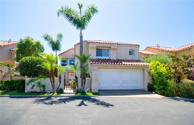 19 Las Cruces, Irvine, CA 92614 - mediterranean / spanish-style house with driveway, stucco siding, an attached garage, and a tiled roof