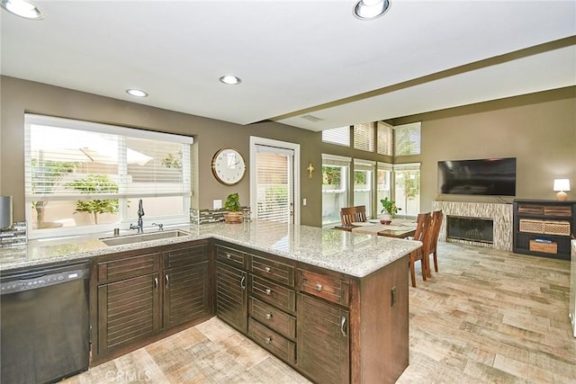 19 Las Cruces, Irvine, CA 92614 - kitchen with dishwasher, a peninsula, light stone counters, a glass covered fireplace, and recessed lighting