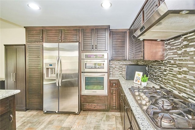 19 Las Cruces, Irvine, CA 92614 - kitchen with stainless steel appliances, under cabinet range hood, tasteful backsplash, light wood-style flooring, and recessed lighting