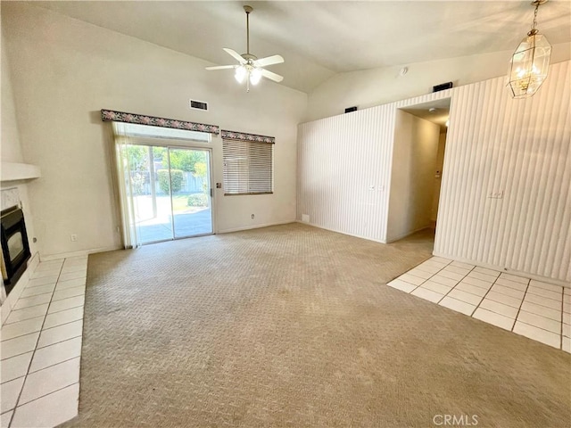 224 Stonewood Dr, Los Banos, CA 93635 - unfurnished living room with carpet, vaulted ceiling, ceiling fan, a glass covered fireplace, and tile patterned floors
