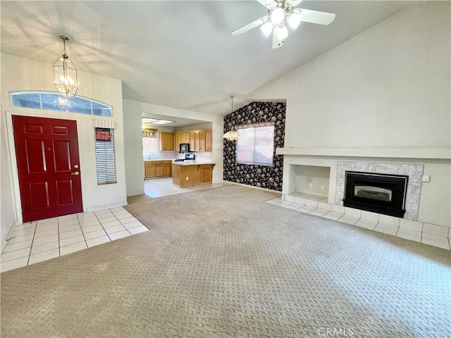 224 Stonewood Dr, Los Banos, CA 93635 - unfurnished living room with light colored carpet, vaulted ceiling, a chandelier, a premium fireplace, and a ceiling fan