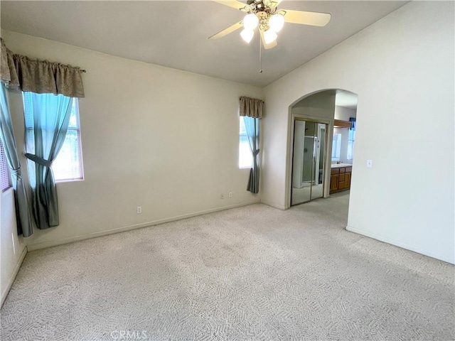 224 Stonewood Dr, Los Banos, CA 93635 - spare room with arched walkways, light colored carpet, a ceiling fan, and lofted ceiling