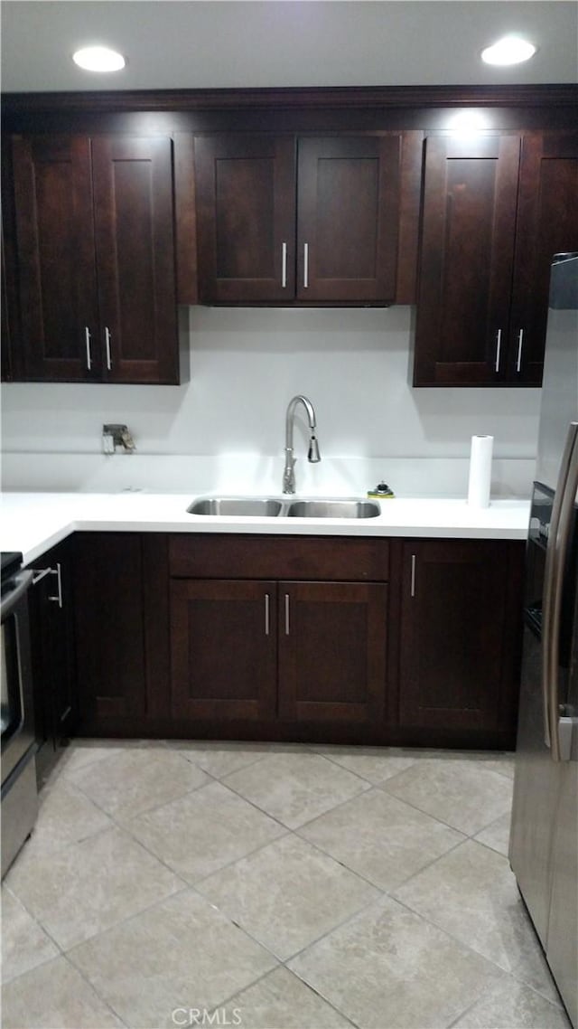 545 Chestnut Ave Unit 207, Long Beach, CA 90802 - kitchen with appliances with stainless steel finishes, light countertops, dark brown cabinets, light tile patterned floors, and recessed lighting