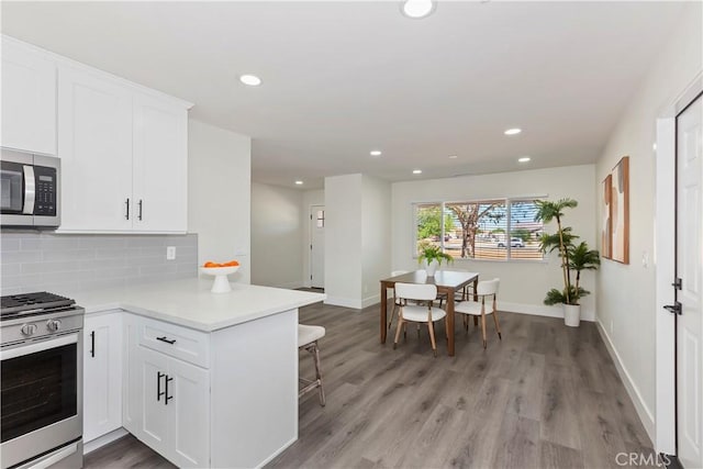 15615 Erie Rd, Apple Valley, CA 92307 - kitchen with appliances with stainless steel finishes, a peninsula, recessed lighting, light countertops, and decorative backsplash