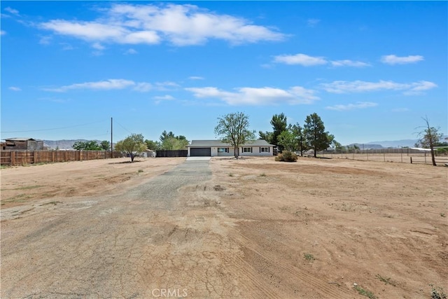 15615 Erie Rd, Apple Valley, CA 92307 - view of yard featuring a garage, driveway, and a view of rural / pastoral area