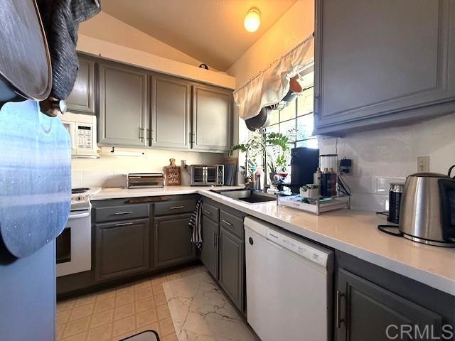 911 Concord Ct, Vista, CA 92081 - kitchen with white appliances, gray cabinetry, vaulted ceiling, and light countertops