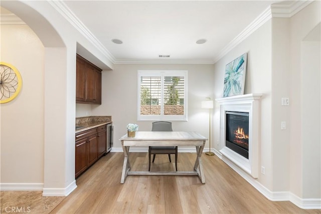 11645 Wiggins Ct, Yucaipa, CA 92399 - office featuring light wood-style flooring, a glass covered fireplace, arched walkways, and crown molding