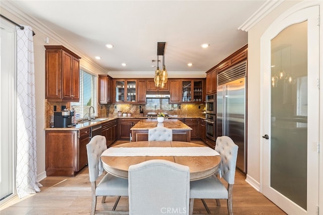 11645 Wiggins Ct, Yucaipa, CA 92399 - kitchen featuring stainless steel appliances, under cabinet range hood, a center island, glass insert cabinets, and tasteful backsplash