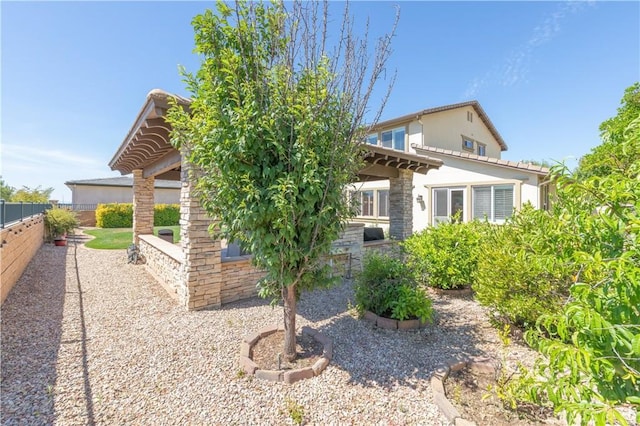 11645 Wiggins Ct, Yucaipa, CA 92399 - view of side of property featuring a fenced backyard, stone siding, a patio, and stucco siding
