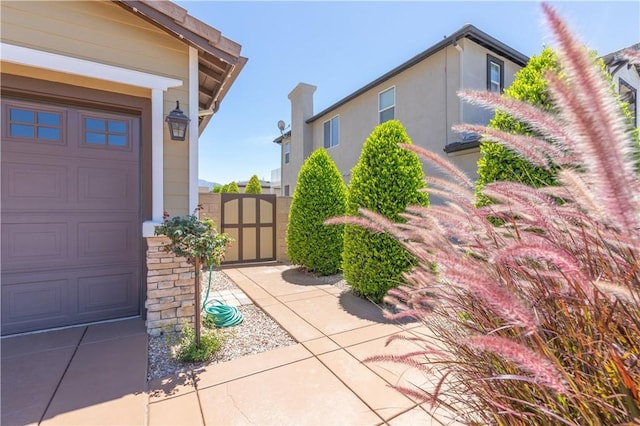 11645 Wiggins Ct, Yucaipa, CA 92399 - view of exterior entry featuring a gate, stucco siding, and a chimney