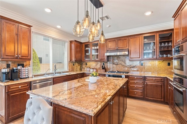 11645 Wiggins Ct, Yucaipa, CA 92399 - kitchen with under cabinet range hood, appliances with stainless steel finishes, light stone countertops, pendant lighting, and a chandelier