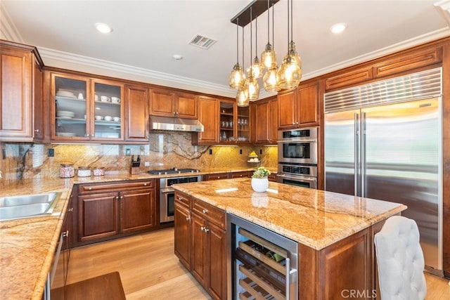 11645 Wiggins Ct, Yucaipa, CA 92399 - kitchen featuring appliances with stainless steel finishes, beverage cooler, under cabinet range hood, a center island, and hanging light fixtures