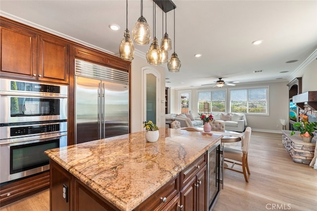 11645 Wiggins Ct, Yucaipa, CA 92399 - kitchen featuring appliances with stainless steel finishes, crown molding, wine cooler, light stone counters, and decorative light fixtures