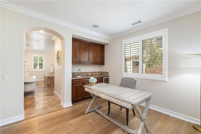 11645 Wiggins Ct, Yucaipa, CA 92399 - dining room featuring arched walkways, crown molding, light wood finished floors, and bar with sink