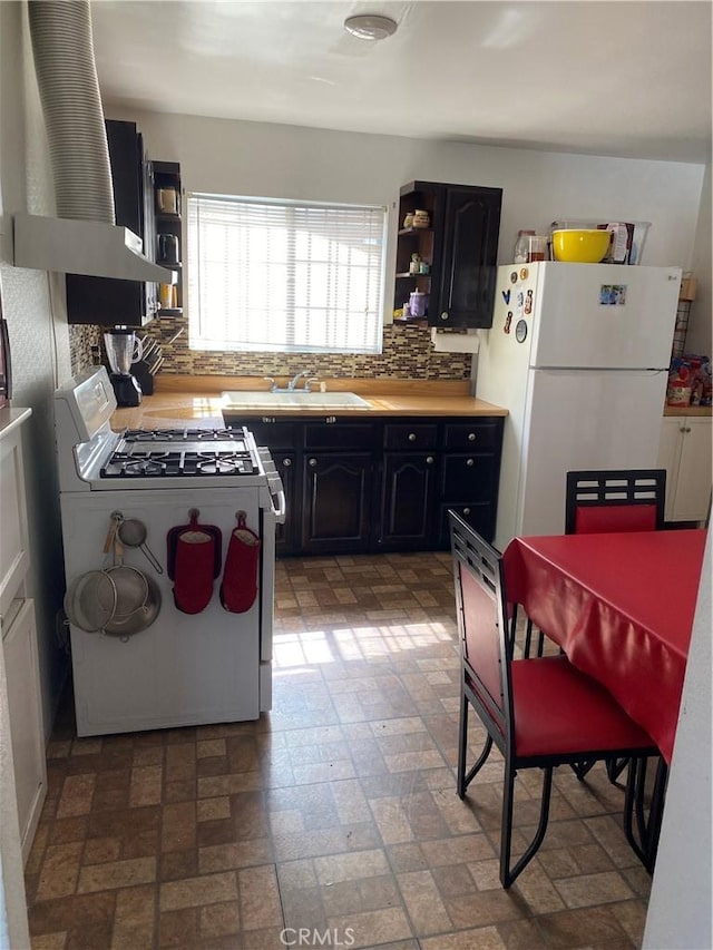 427 W 92nd St, Los Angeles, CA 90003 - kitchen featuring white appliances, open shelves, decorative backsplash, brick patterned floors, and dark cabinetry
