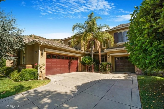 57 Mountain Laurel Way, Azusa, CA 91702 - view of front facade featuring stucco siding, concrete driveway, and a garage