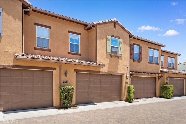 2437 Sanabria Ln, Brea, CA 92821 - mediterranean / spanish-style home featuring a tile roof, stucco siding, and an attached garage