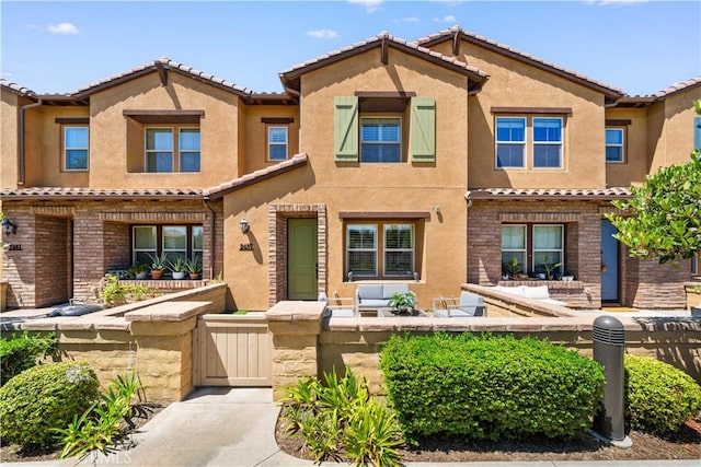 2437 Sanabria Ln, Brea, CA 92821 - mediterranean / spanish house featuring a tiled roof, a fenced front yard, stucco siding, and a gate