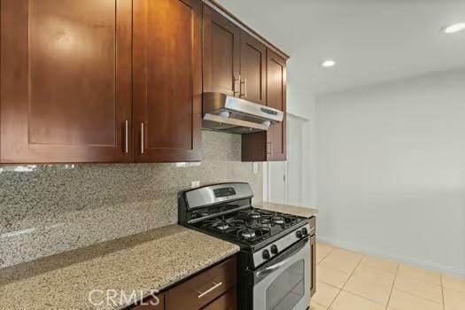 4775 Beverly Ct, Riverside, CA 92506 - kitchen with under cabinet range hood, stainless steel range with gas stovetop, light tile patterned flooring, backsplash, and recessed lighting