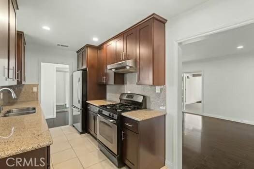 4775 Beverly Ct, Riverside, CA 92506 - kitchen featuring stainless steel appliances, under cabinet range hood, decorative backsplash, recessed lighting, and light stone countertops