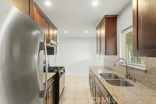 4775 Beverly Ct, Riverside, CA 92506 - kitchen with freestanding refrigerator, gas range, light stone counters, light tile patterned floors, and recessed lighting