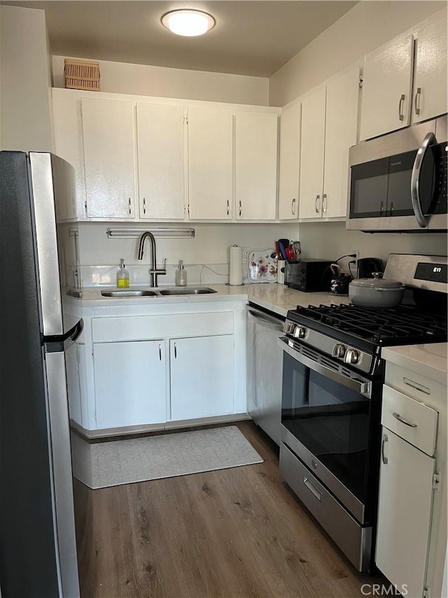 800 W 1st St Unit 2002, Los Angeles, CA 90012 - kitchen featuring stainless steel appliances, dark wood finished floors, light countertops, and white cabinets