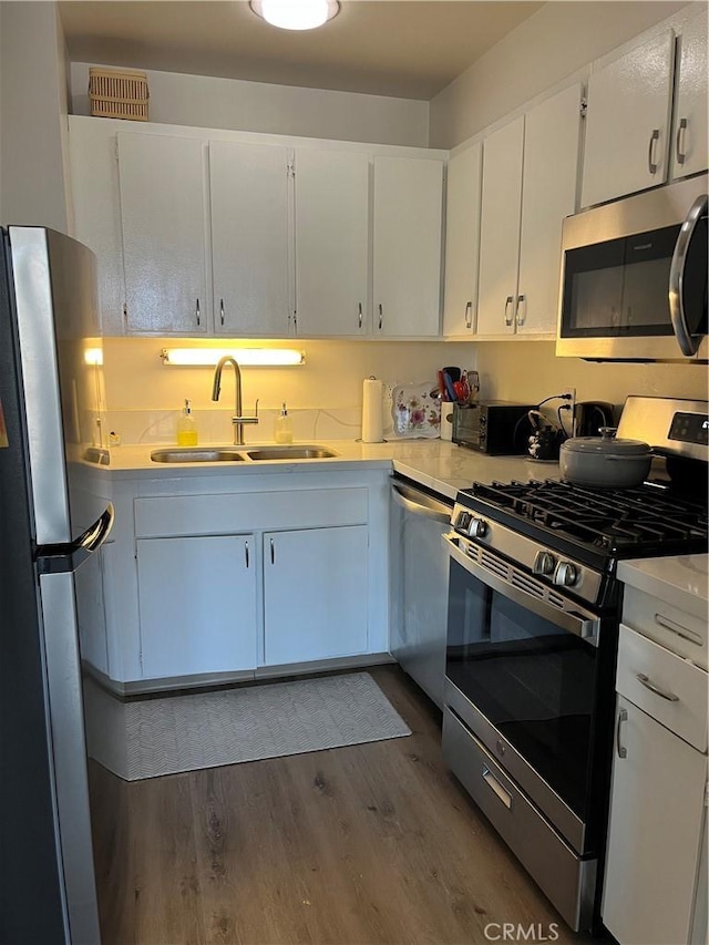800 W 1st St Unit 2002, Los Angeles, CA 90012 - kitchen with appliances with stainless steel finishes, light countertops, dark wood finished floors, and white cabinets