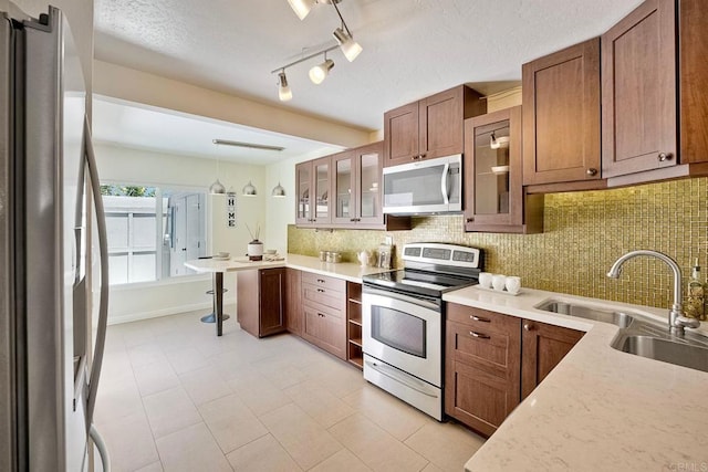 6229 Caminito Basilio, San Diego, CA 92111 - kitchen featuring stainless steel appliances, backsplash, glass insert cabinets, decorative light fixtures, and a textured ceiling