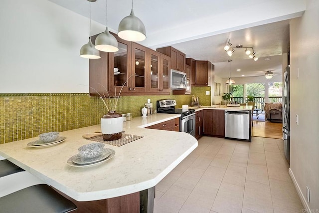 6229 Caminito Basilio, San Diego, CA 92111 - kitchen featuring stainless steel appliances, a peninsula, light tile patterned floors, glass insert cabinets, and tasteful backsplash