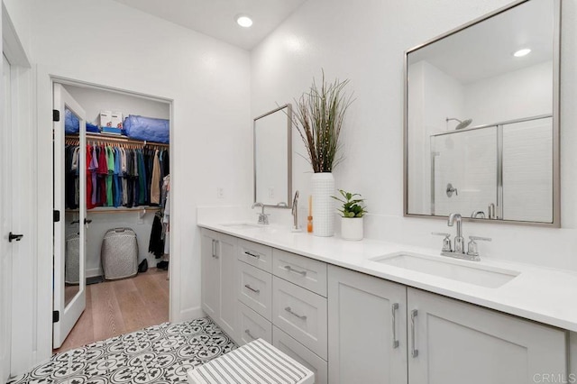 2051 Julie Dawn Pl, Escondido, CA 92026 - bathroom featuring double vanity, a shower stall, a spacious closet, wood finished floors, and recessed lighting