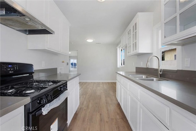 1435 E Colon St, Wilmington, CA 90744 - kitchen with black range with gas cooktop, under cabinet range hood, light wood finished floors, and white cabinets