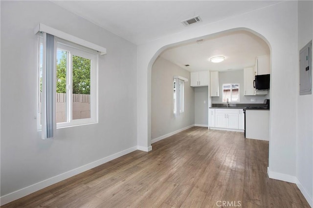 1435 E Colon St, Wilmington, CA 90744 - unfurnished living room with arched walkways, plenty of natural light, and wood finished floors