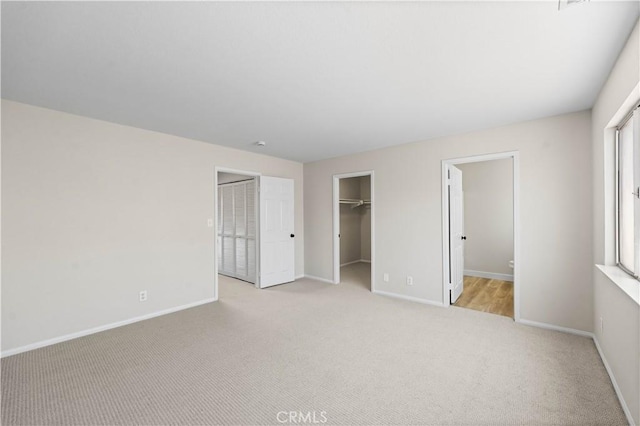 43441 30th St W Unit 3, Lancaster, CA 93536 - unfurnished bedroom with light carpet, a walk in closet, and connected bathroom