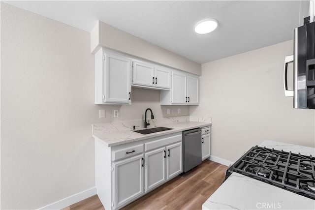 43441 30th St W Unit 3, Lancaster, CA 93536 - kitchen featuring dishwasher, light wood-style flooring, white cabinetry, light stone counters, and gas stove