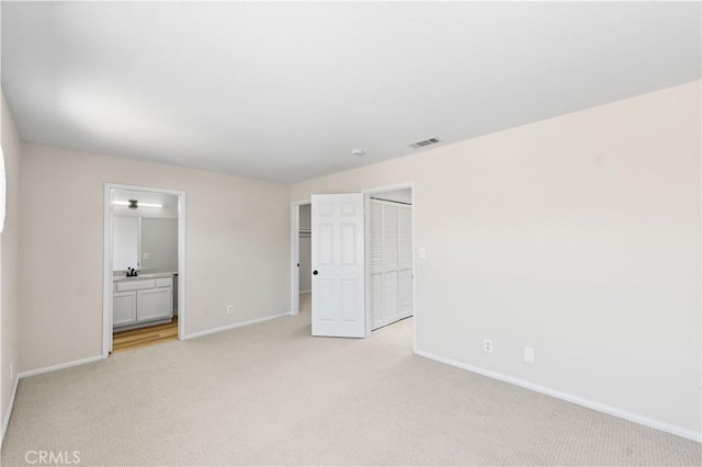 43441 30th St W Unit 3, Lancaster, CA 93536 - unfurnished bedroom featuring light colored carpet, ensuite bathroom, and a closet