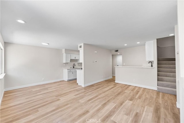 43441 30th St W Unit 3, Lancaster, CA 93536 - unfurnished living room featuring recessed lighting, light wood finished floors, and stairway