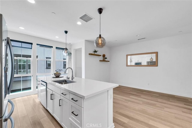 791 S Mosaic St, Anaheim, CA 92805 - kitchen with appliances with stainless steel finishes, light wood-style flooring, white cabinets, light countertops, and an island with sink