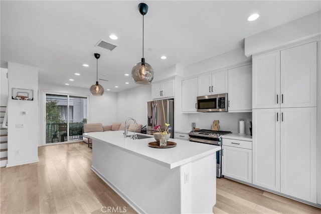791 S Mosaic St, Anaheim, CA 92805 - kitchen with stainless steel appliances, white cabinets, a center island with sink, light countertops, and recessed lighting