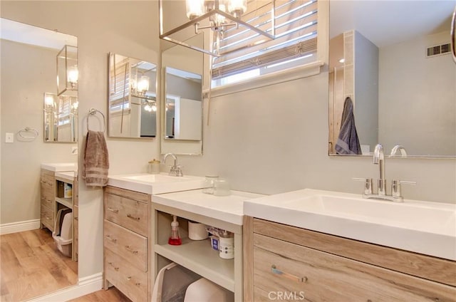 1523 Finegrove Ave, Hacienda Heights, CA 91745 - bathroom featuring two vanities, wood finished floors, and a chandelier