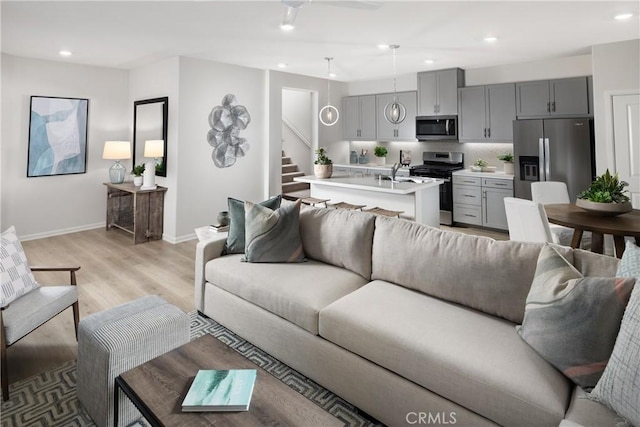 25172 Hunter Ave, Moreno Valley, CA 92551 - living room featuring stairway, recessed lighting, light wood finished floors, and a ceiling fan