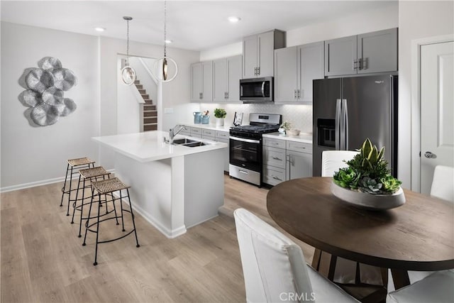 25172 Hunter Ave, Moreno Valley, CA 92551 - kitchen featuring stainless steel appliances, a center island with sink, light wood-style floors, recessed lighting, and gray cabinets