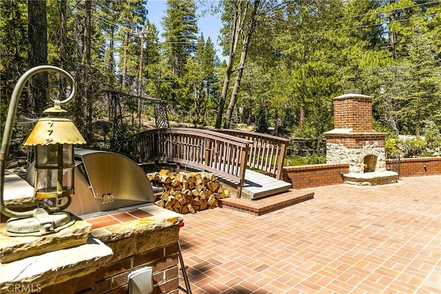 514 Riviera Dr, Lake Arrowhead, CA 92352 - view of patio / terrace with exterior fireplace and view of wooded area