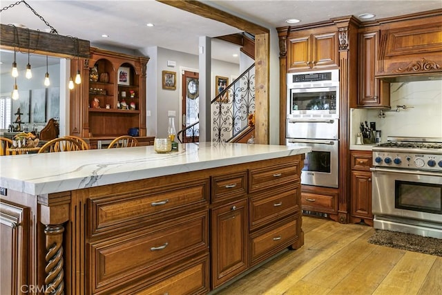 514 Riviera Dr, Lake Arrowhead, CA 92352 - kitchen with stainless steel appliances, light wood-type flooring, premium range hood, pendant lighting, and light stone counters