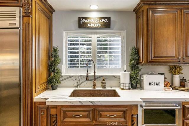 514 Riviera Dr, Lake Arrowhead, CA 92352 - kitchen with built in fridge, light stone counters, brown cabinetry, and tasteful backsplash