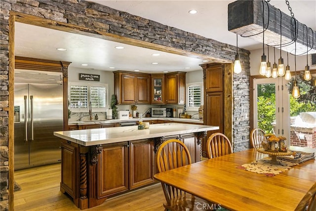 514 Riviera Dr, Lake Arrowhead, CA 92352 - kitchen featuring built in refrigerator, light countertops, an island with sink, light wood-type flooring, and healthy amount of natural light