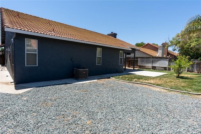 658 Tusky Ave, Los Banos, CA 93635 - back of house with a tiled roof, a chimney, stucco siding, and a patio area