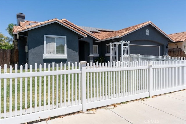 658 Tusky Ave, Los Banos, CA 93635 - view of front of property with a tiled roof, a fenced front yard, stucco siding, a chimney, and an attached garage