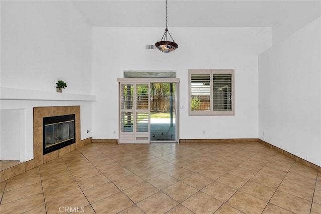 658 Tusky Ave, Los Banos, CA 93635 - unfurnished living room with light tile patterned flooring, a fireplace, and a towering ceiling