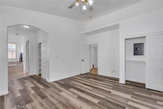 658 Tusky Ave, Los Banos, CA 93635 - unfurnished living room with arched walkways, ceiling fan, electric panel, and wood finished floors