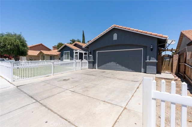 658 Tusky Ave, Los Banos, CA 93635 - ranch-style house with concrete driveway, stucco siding, a garage, a fenced front yard, and a tiled roof